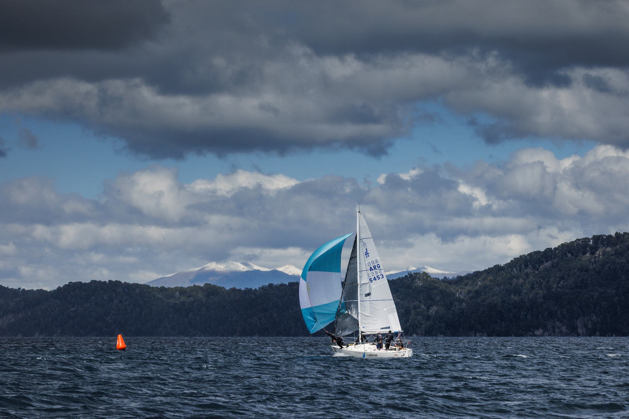 El Tata Patagonia con el spinnaker argentino bajo nubes de tormenta en el Nahuel Huapi