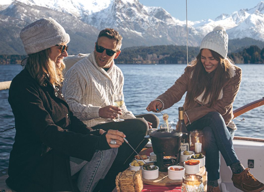 Invitados disfrutando una picada a bordo en el lago Nahuel Huapi